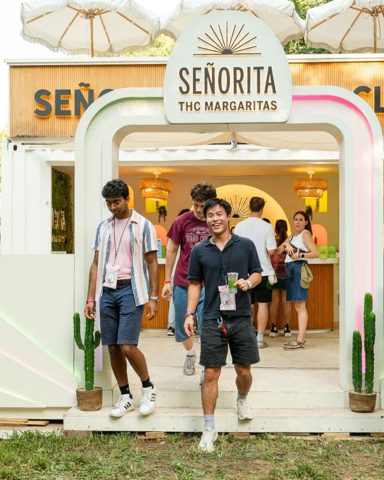 Smiling festival goer walking out of the Señorita THC Margaritas club activation at Shaky Knees Music Festival with a drink in hand