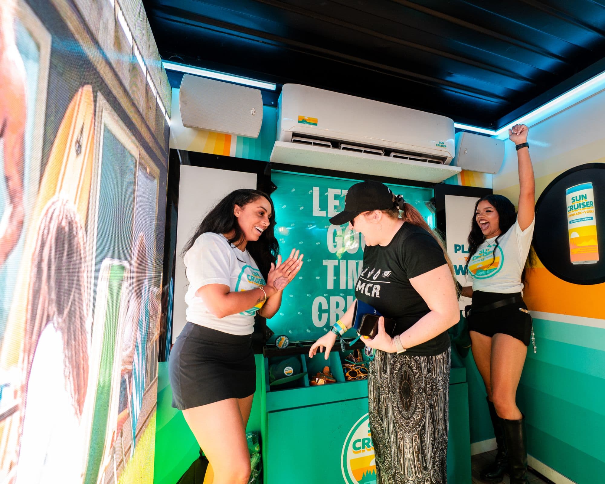 Festival goer celebrating with Sun Cruiser brand ambassadors after playing the indoor prize game at Shaky Knees Music Festival